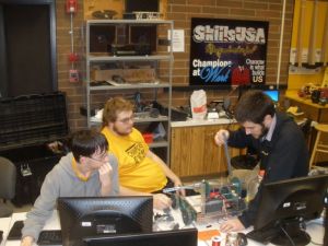 Harley Wheeler (far left) and Jesse McDonald (middle), both juniors at Lewiston High School, talk over the design of their robot's arm with mentor Bryce Winterbottom, an associate mechanical engineer at Schweitzer Engineering Laboratories. Their robot received a silver award at the Idaho SKILLS USA competition. 