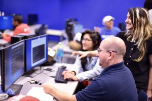 An instructor and students discuss computer code at Miami Dade College.