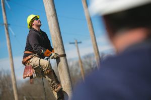 man climbing telephone pole