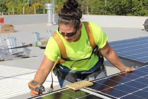 student installing solar panels