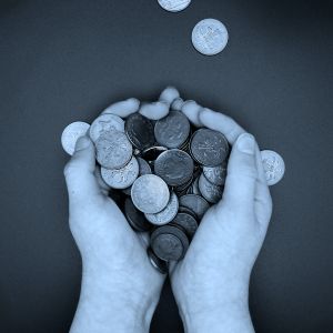 An image of two hands holding some coins