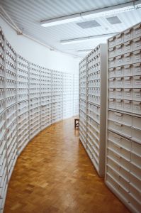 An image of an archival hallway with tall stacks of file cabinets
