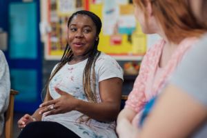 A photo of two women in a classroom setting talking